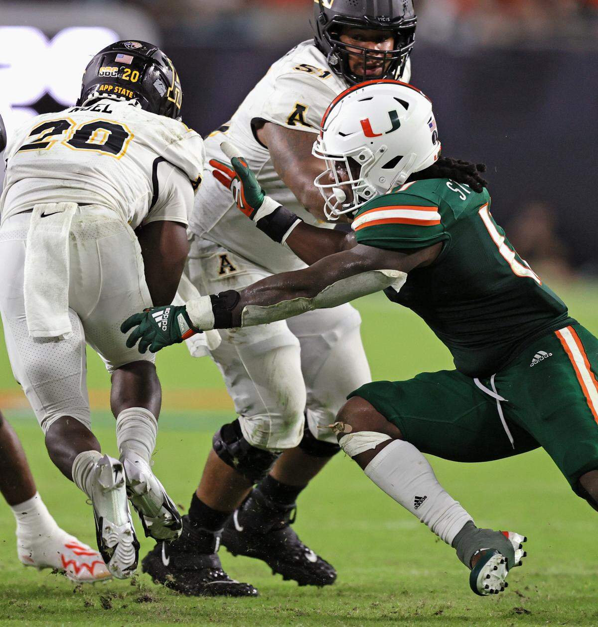 Appalachian State Mountaineers offensive lineman Baer Hunter (51) protect Mountaineers running back Nate Noel (20) from Miami Hurricanes linebacker Waynmon Steed (17) during the third quarter of their ACC football game at Hard Rock Stadium on Saturday, September 11, 2021 in Miami Gardens, Florida.