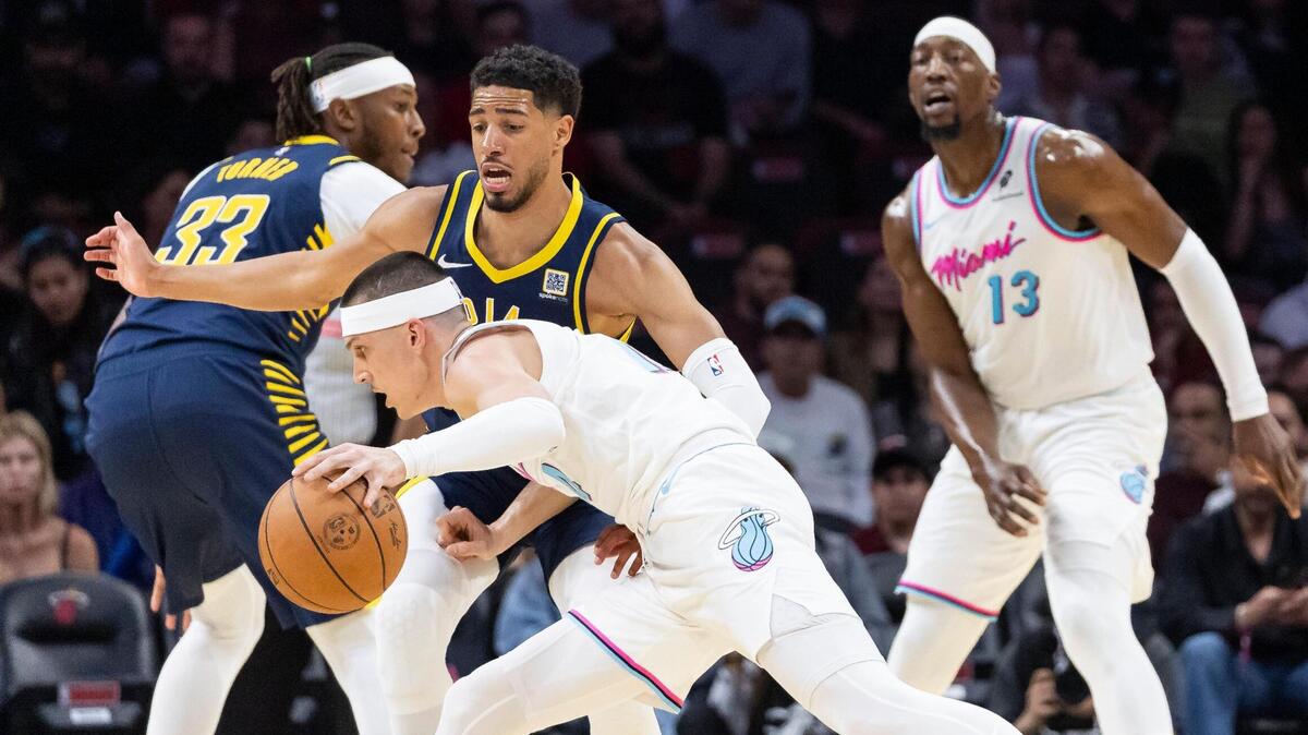 Miami Heat guard Tyler Herro (14) drives the ball as Indiana Pacers guard Tyrese Haliburton (0) defends in the first half of their NBA game at Kaseya Center on Feb. 28, 2025, in Miami.