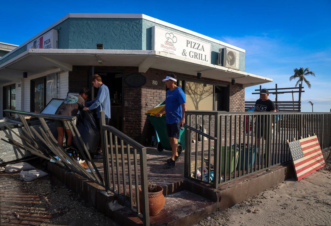 Workers and friends of “Bella Mozzarella” cleaned up the pizza and grill after Hurricane Milton made its way onshore in Ft. Myers Beach on Thursday, October 10, 2024. Two years after Hurricane Ian devastated the small barrier island of Fort Myers Beach, killing 14 people and leaving almost every home and business in ruins, the lives of residents and shopkeepers who heeded warnings to get out as another powerful storm approached were spared.