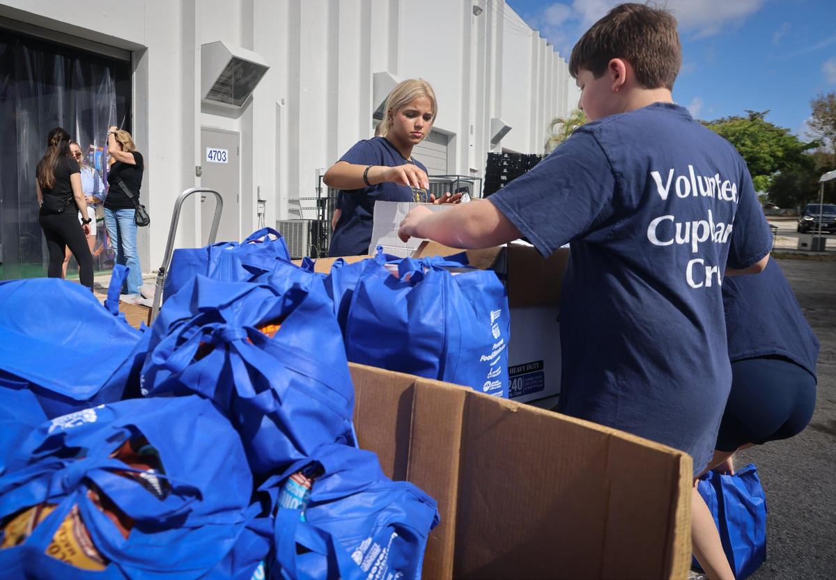 Several Broward high school volunteers - Sophia Gonzalez, 17, center, and Jonathan Alperstein, 12, right, sort, stock, and pack kosher and non-perishable food items as part of the Goodman Jewish Family Services food panty’s annual Passover event.