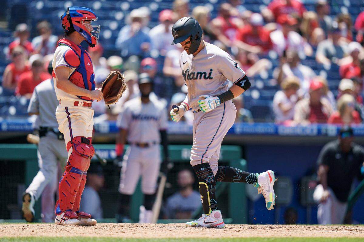 Miami Marlins’ Miguel Rojas, right, comes in to score on his home run as Philadelphia Phillies catcher Garrett Stubbs, left, looks on during the fifth inning of a baseball game, Wednesday, June 15, 2022, in Philadelphia. (AP Photo/Chris Szagola)