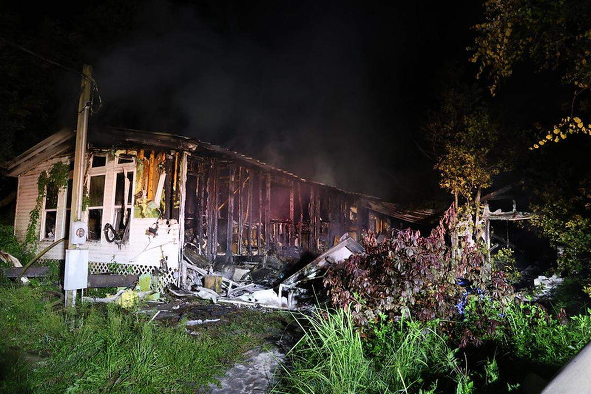 Fire department officials say the initial 911 call came “from a homeowner reporting smoke and flames inside their home, with three adults and five dogs trapped inside.”