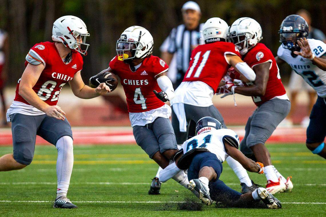 Cardinal Gibbons running back Tre’Mone Drisdom (4) runs with the ball as he dodges a Miami Palmetto player during the football preseason exhibition at Cardinal Gibbons High School in Fort Lauderdale, Florida, on Thursday, August 18, 2022