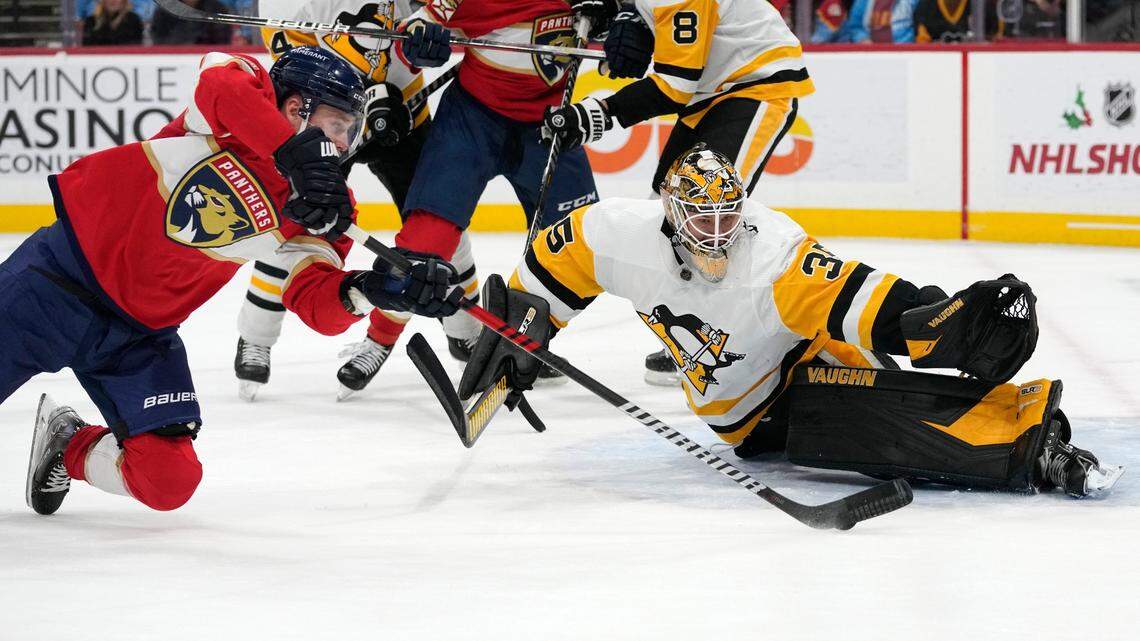Pittsburgh Penguins goaltender Tristan Jarry (35) defends a shot on the goal by Florida Panthers center Sam Bennett, left, during the second period of an NHL hockey game, Thursday, Dec. 15, 2022, in Sunrise, Fla. (AP Photo/Lynne Sladky)