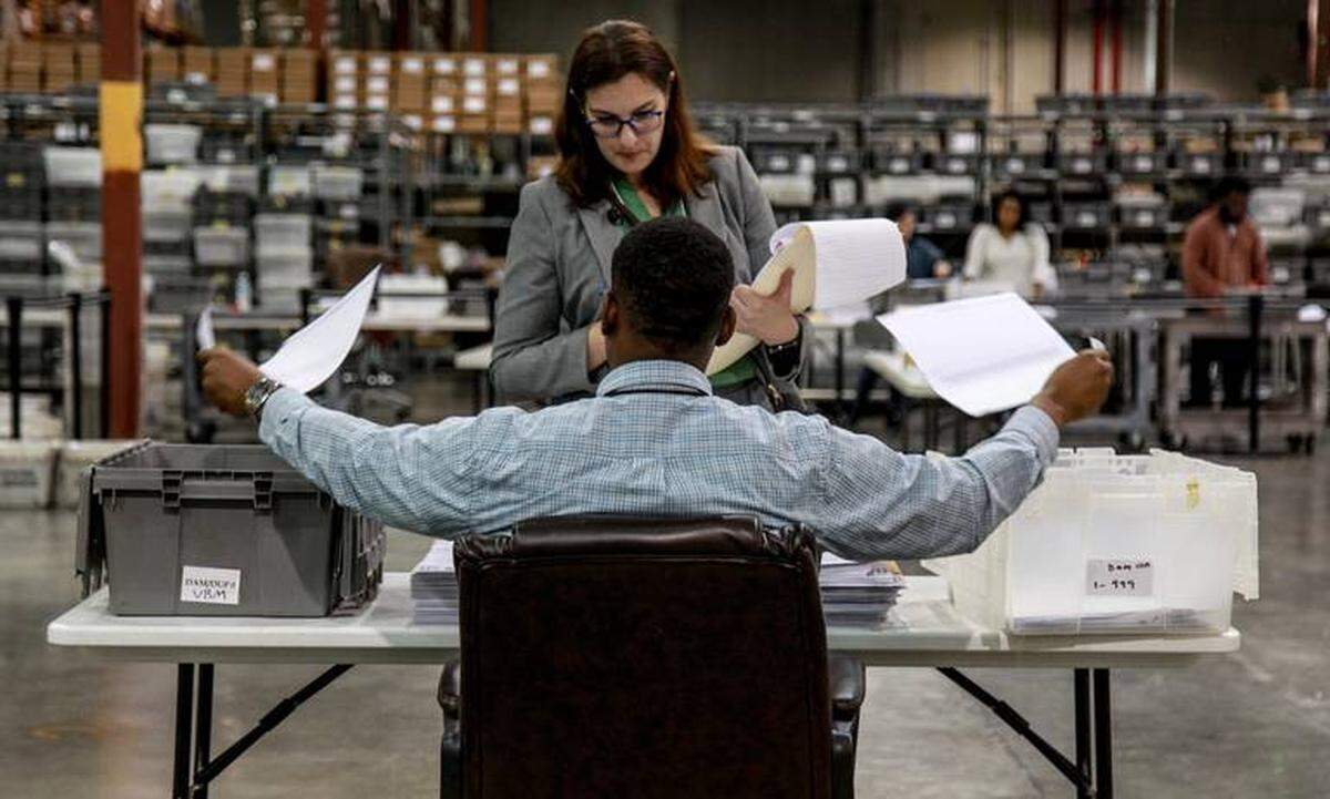 An attorney observes a voting technician sort ballots at a Palm Beach Supervisor of Elections facility in Riviera Beach, Fla., Wednesday, Nov. 14, 2018.
