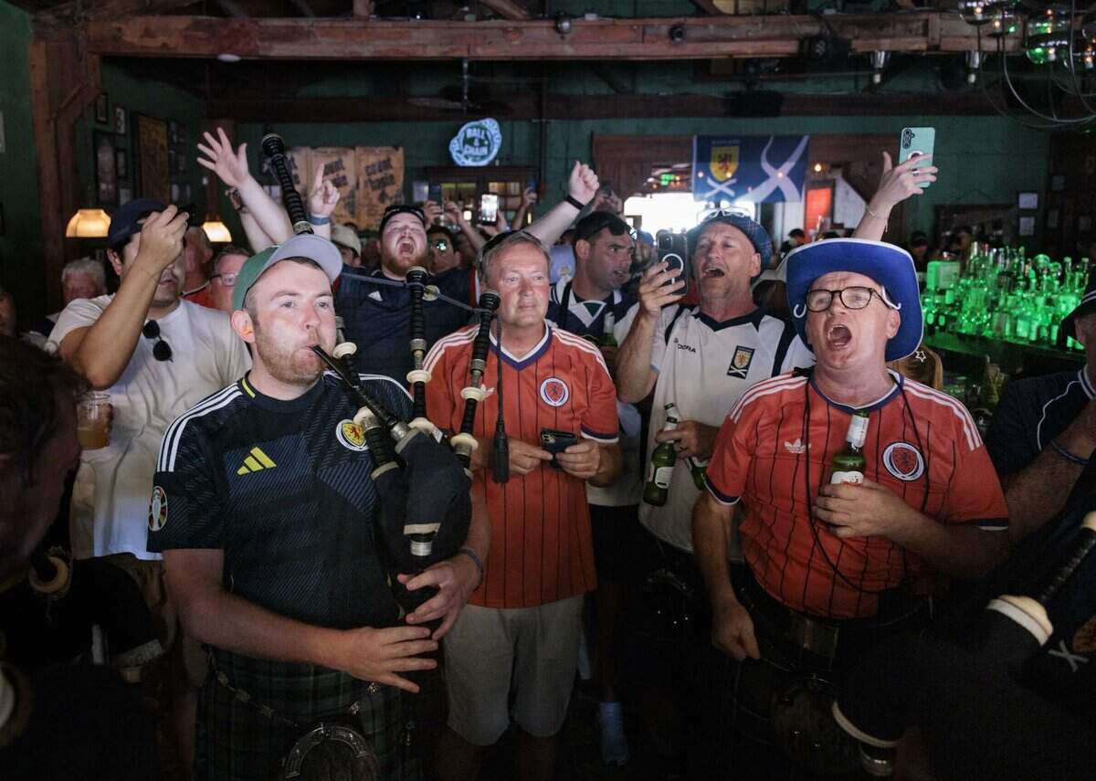 Connor Jardine, left, plays the bagpipes with other people he met in a Facebook group of Tartan fans coming to Miami while other Scots sing a song during a gathering of Tartan Army, Scottish National Football team fans, at Ball & Chain on Monday, June 22, 2026, before a parade down Calle Ocho in Miami, Fla.