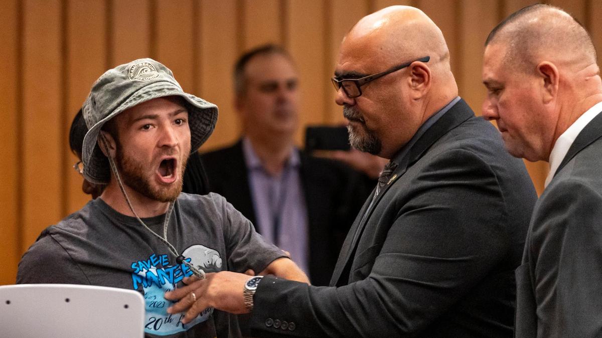 Un hombre es expulsado de la cámara de la Comisión de Miami-Dade después de gritar su oposición al parque acuático Miami Wilds,durante la reunión de la Comisión el 6 de septiembre de 2023.