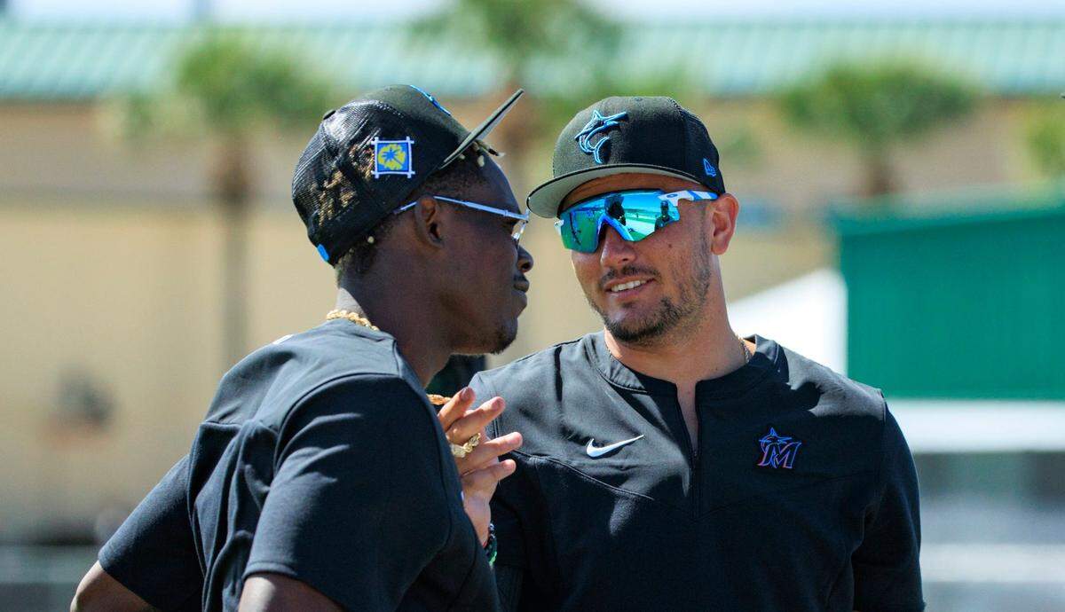 Miami Marlins second baseman Jazz Chisholm talks with teammate Miguel Rojas during the first full-squad spring training workout at Roger Dean Chevrolet Stadium on Monday, March 14, 2022 in Jupiter, FL.