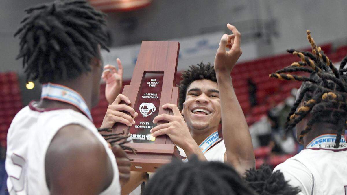 Norland’s Triston Wilson (2,) the game-high scorer with 23 points, hoists the State Championship trophy after the Class 5A final against Blake during the Florida High School State Championships at the RP Funding Center in Lakeland, Fl on Friday March 8, 2024. Norland defeated Blake 61-48 to win the State Title. Scott Wheeler | Photo