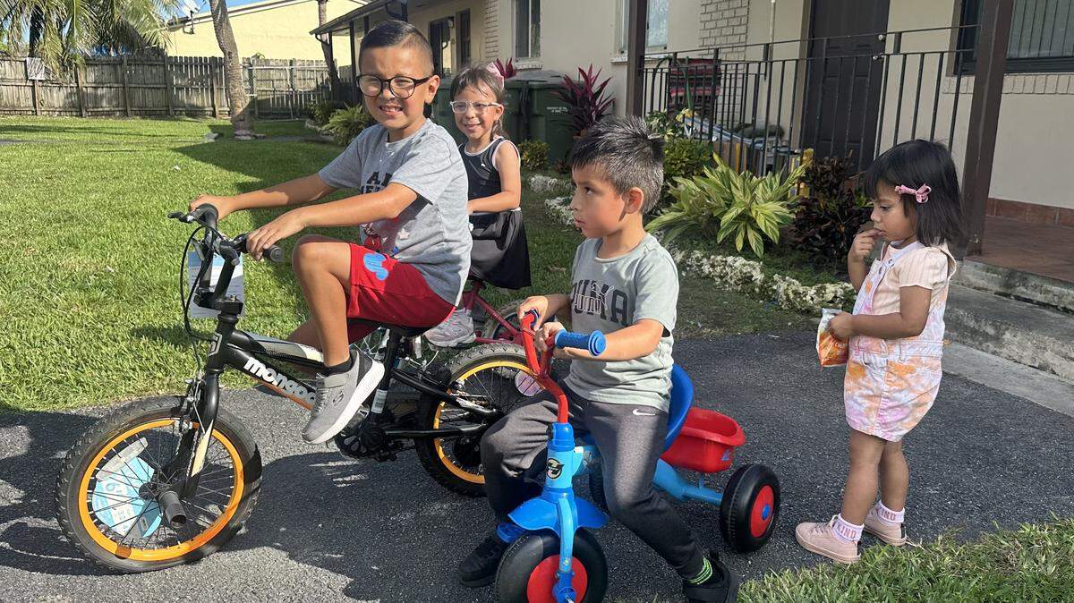 Some of Angela De Borja's grandchildren ride their bikes outside their Miami home. Angela has been raising the kids on her own since their mother was detained by immigration agents and deported to Guatemala.