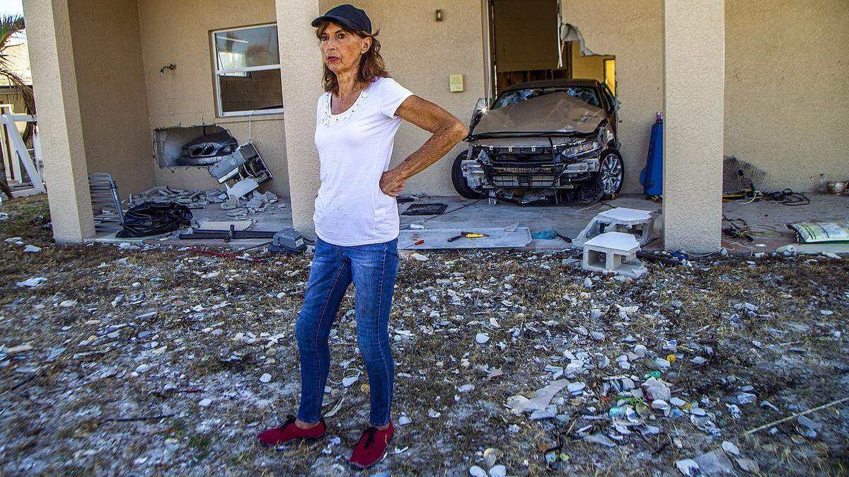 Fort Myers resident JoAnn Knobloch stands in the yard of her badly damaged Estero Boulevard house on Wednesday, Oct. 26, 2022. Knobloch’s husband drowned in Hurricane Ian’s storm surge a month earlier.