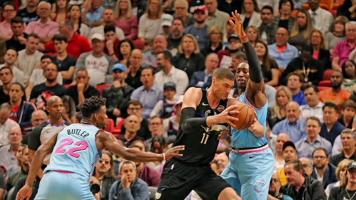Miami Heat’s Jimmy Butler (22) and Bam Adebayo (13) guard Milwaukee Bucks center Robin Lopez (42) in the second quarter at AmericanAirlines Arena in Miami, Florida, March 2, 2020.