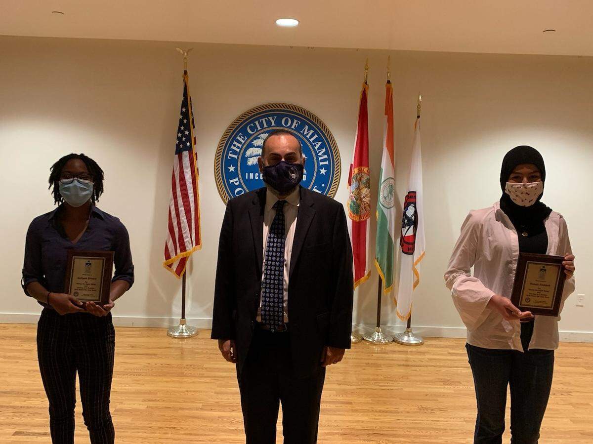 School for Advanced Studies students Aaliyah Brown, left, and Betule Zlekhah were selected by the Do the Right Thing organization as winners for their community service projects. Aaliyah and Betule stand with Principal Omar Monteagudo during a ceremony at the City of Miami police academy auditorium in downtown Miami.