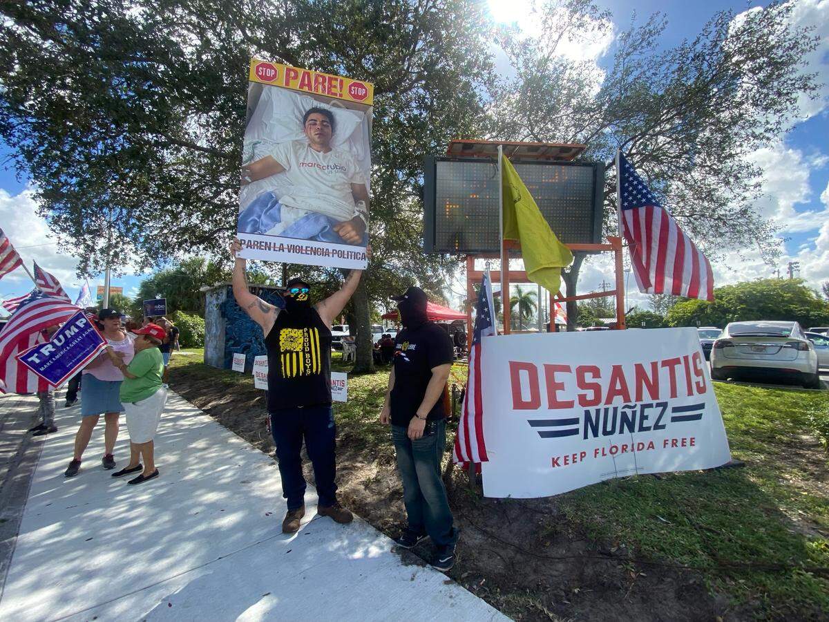 Un miembro de los Proud Boys se concentra con otros en apoyo de Christopher Monzón, un representante del Partido Republicano que, de acuerdo con la policía, fue atacado por otras dos personas la semana pasada mientras llamaba a las puertas de los candidatos republicanos. La protesta tuvo lugar frente a la Biblioteca John F. Kennedy de Hialeah el 29 de octubre de 2022.