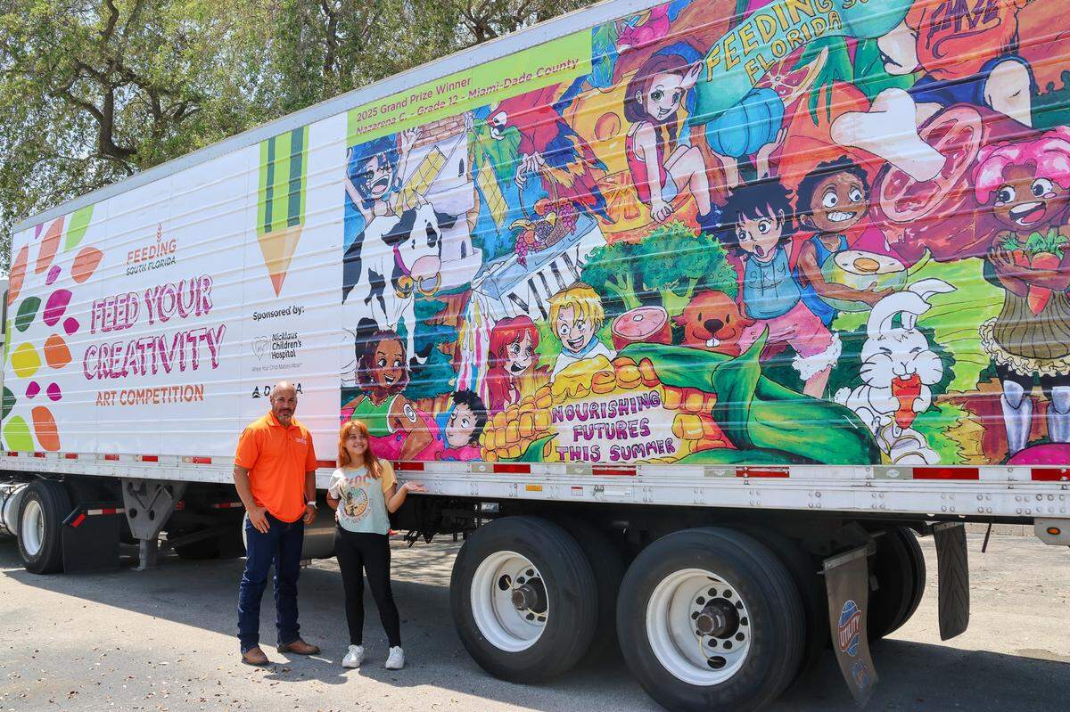 Paco Vélez celebrates the Feeding South Florida semi-trailer truck wrapped with Nazarena Capdevila’s winning art in 2025.