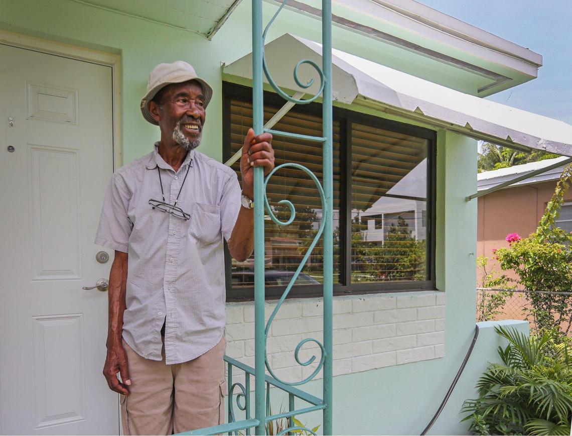 Wilson Williams, 90, a retired Sears maintenance worker, poses on the porch of his longtime home in Miami’s historically Black West Coconut Grove on Wednesday, June 15, 2022. Nonprofit group Rebuilding Together is installing new impact windows at Williams’ house.