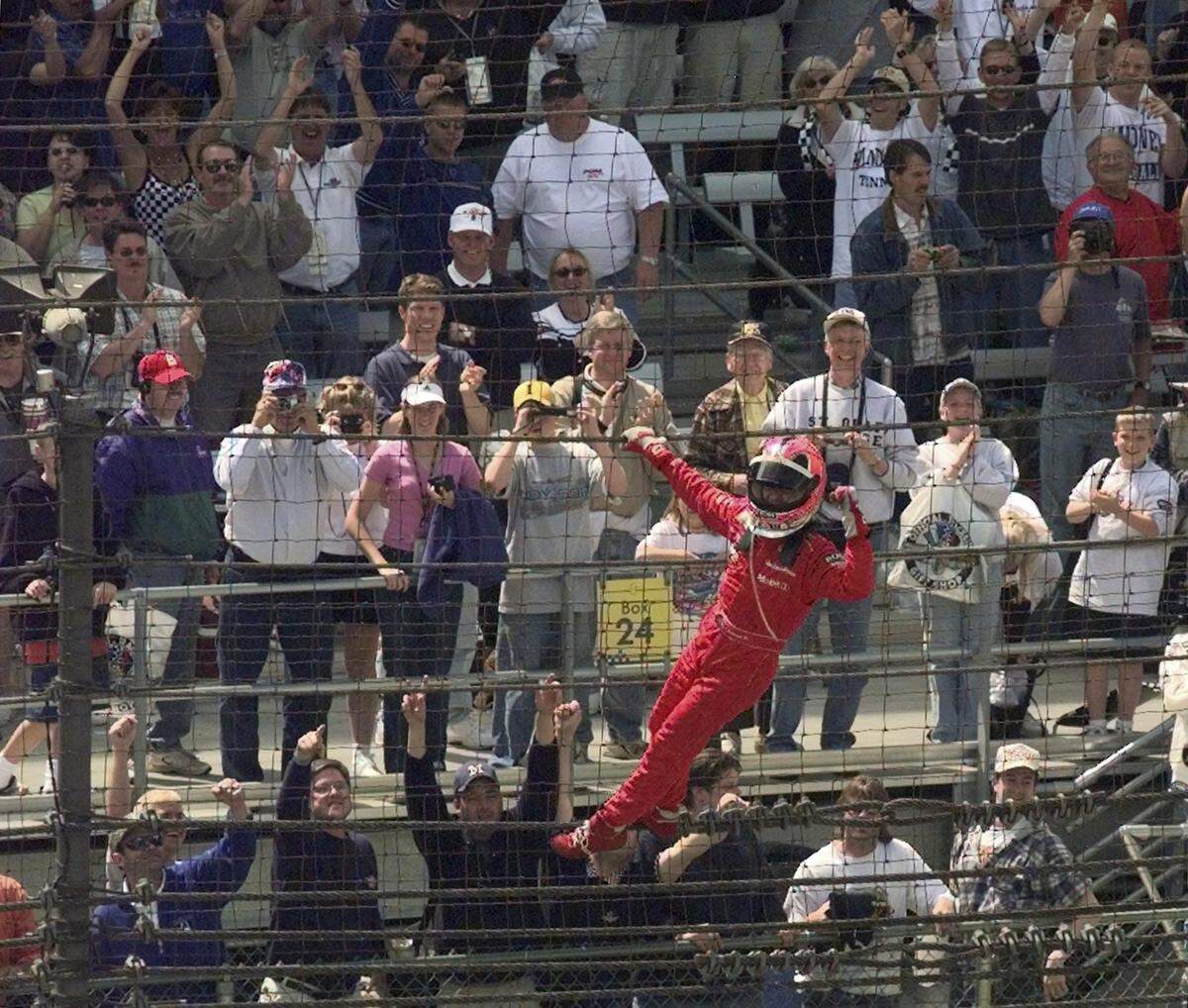 Helio Castroneves of Brazil by way of Coral Gables at the time celebrates after winning the 2001 Indianapolis 500 auto race by climbing the fencing near the start-finish line at the Indianapolis Motor Speedway.