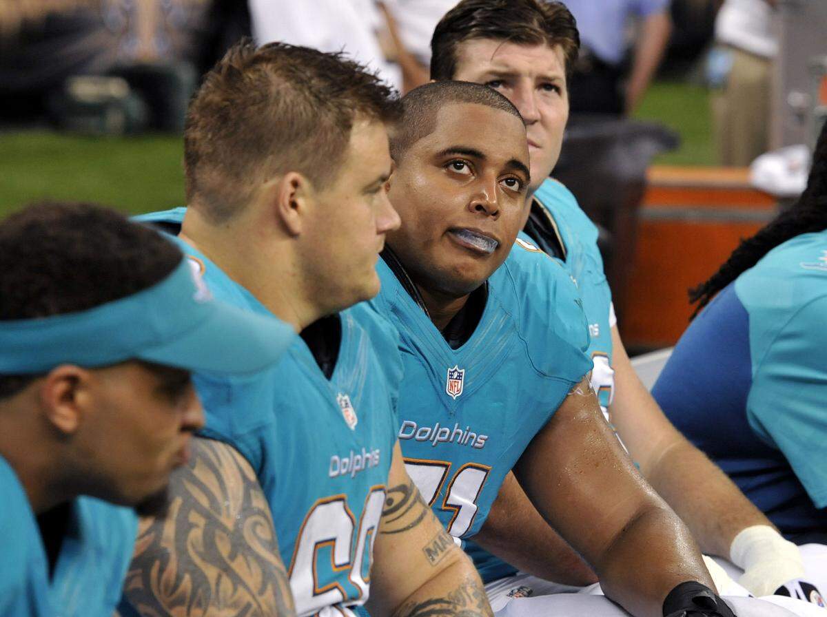 Miami Dolphins guard Richie Incognito (68), center left, and and tackle Jonathan Martin (71), center right, sit on the bench in the second half of an NFL football game against the New Orleans Saints in New Orleans.