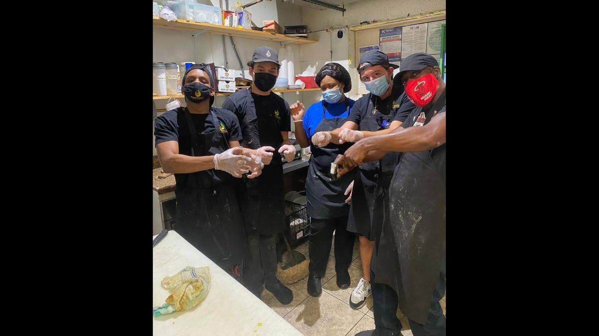 Kitchen staff at Miami Squeeze juice bar and health restaurant in North Miami Beach pose after receiving a $2,021 tip from a loyal patron on Friday, Jan. 1, 2021.