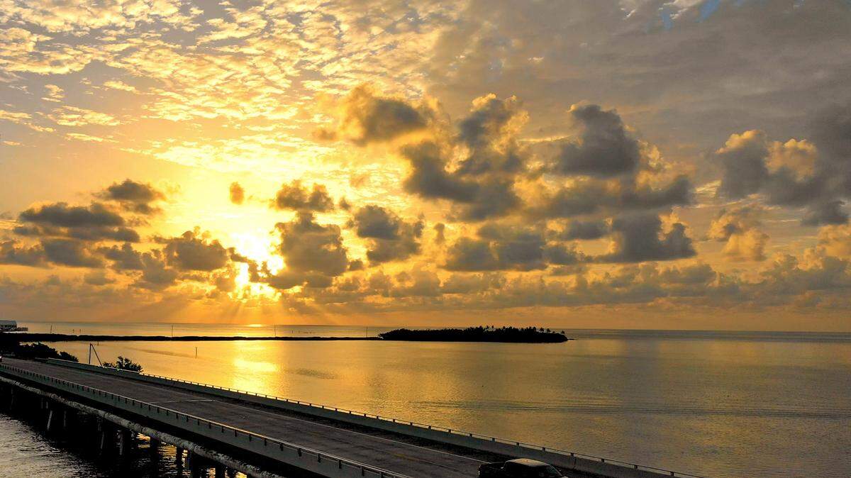 In this aerial photo provided by the Monroe County Tourist Development Council, a vehicle rolls on the Florida Keys Overseas Highway Monday, Sept. 10, 2018.