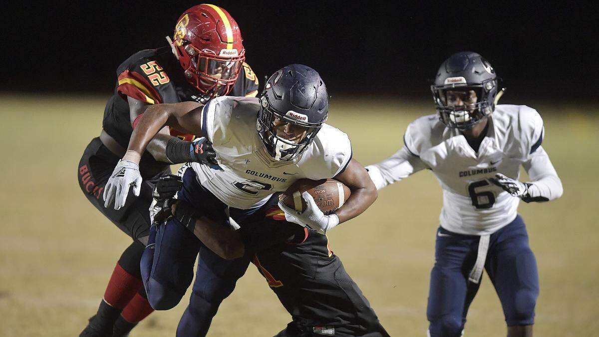 Miami Columbus receiver Kalani Norris is tackled by Deerfield Beach’s Keyon Martin and Gemon Eaford during the first half of their game, Friday, Nov. 30, 2018.