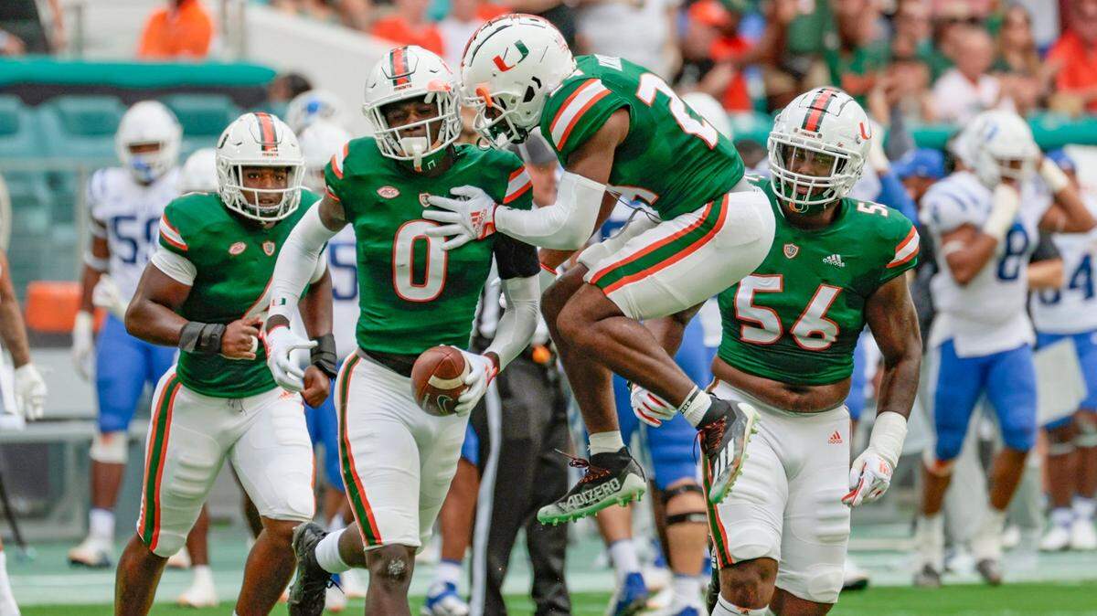 Miami Hurricanes safety Kamren Kinchens (24) celebrates with safety James Williams (0) after Williams intercepts the ball in the first quarter at Hard Rock Stadium in Miami Gardens on Saturday, October 22, 2022.