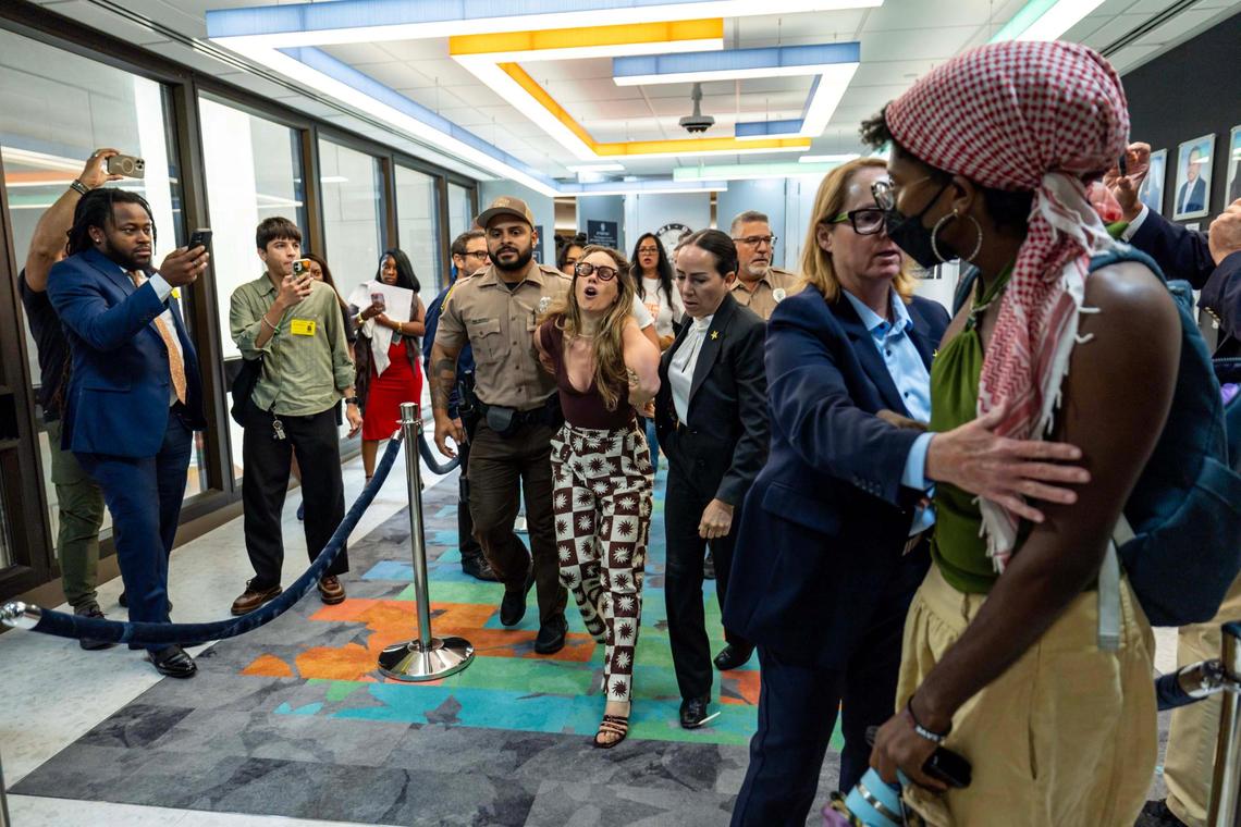 Camila Ramos is forcibly removed from the commission chambers by officers during a Miami-Dade County Commission meeting at the Stephen P. Clark Government Center on Thursday, June 26, 2025, in Miami.