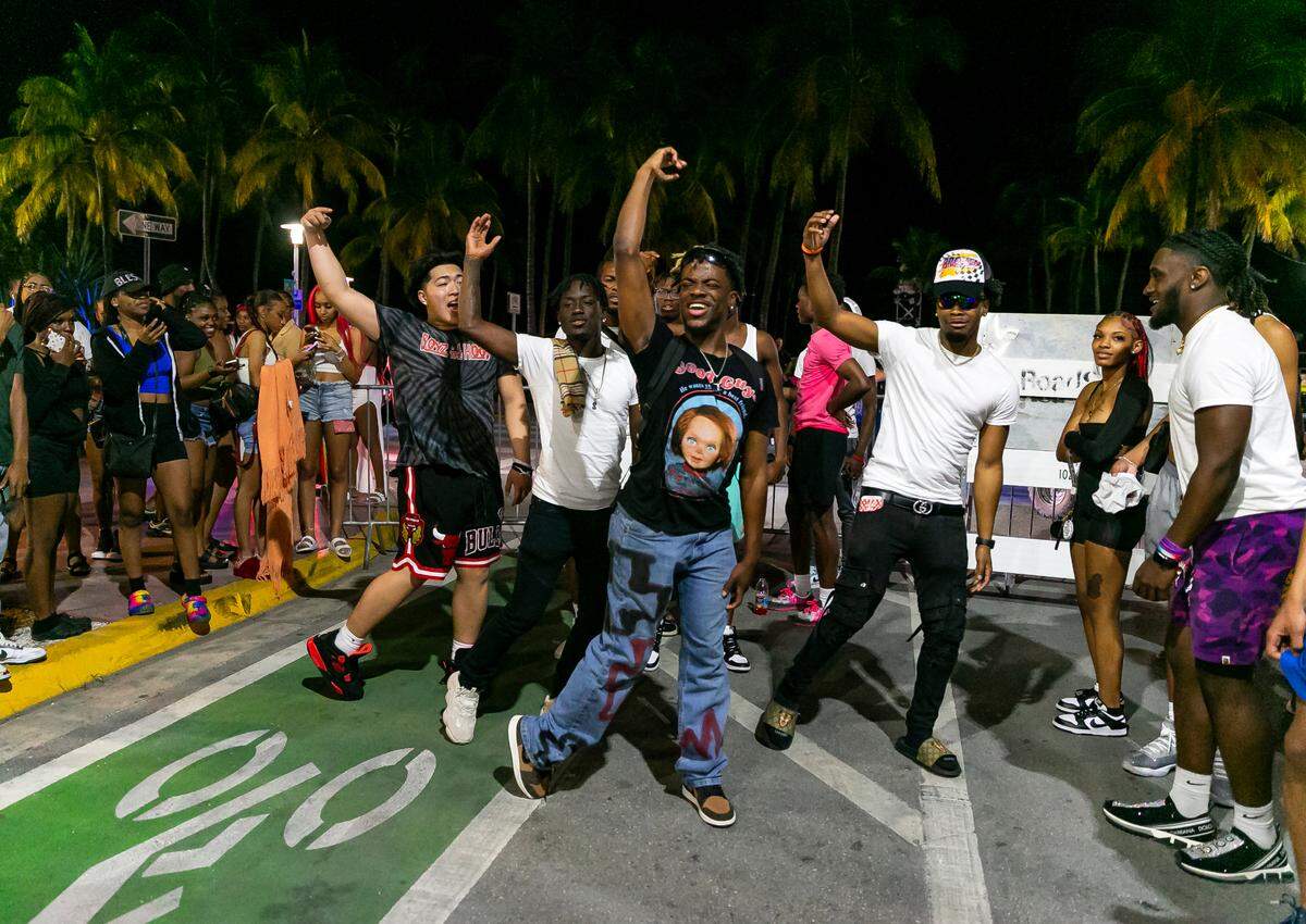 TikToker The Jiggy Prince, center, films a video on Ocean Drive and 8th Street as a crowd of people watch in Miami Beach, Florida on Friday, March 25, 2022. City officials imposed a midnight curfew and forced stores to stop selling alcohol after 6 p.m. The restrictions were set in place after two shootings in Miami Beach the weekend before caused city officials to announce a “state of emergency.”