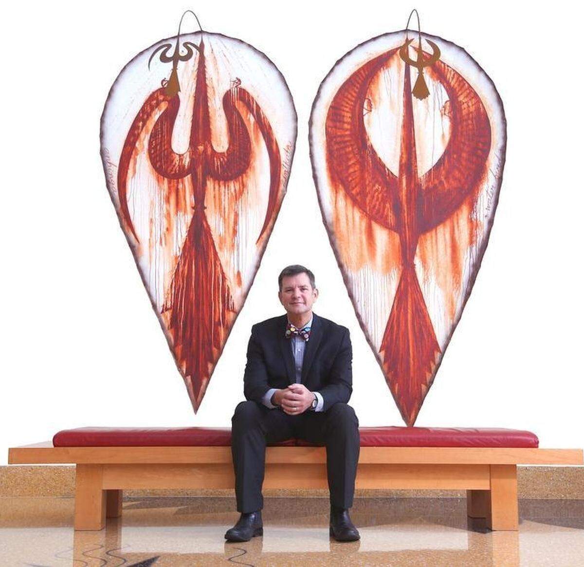 Johann F. Zietsman, president and CEO of the Adrienne Arsht Center for the Performing Arts, sits in the lobby of the Knight Concert Hall in front of artwork by Jose Bedia.