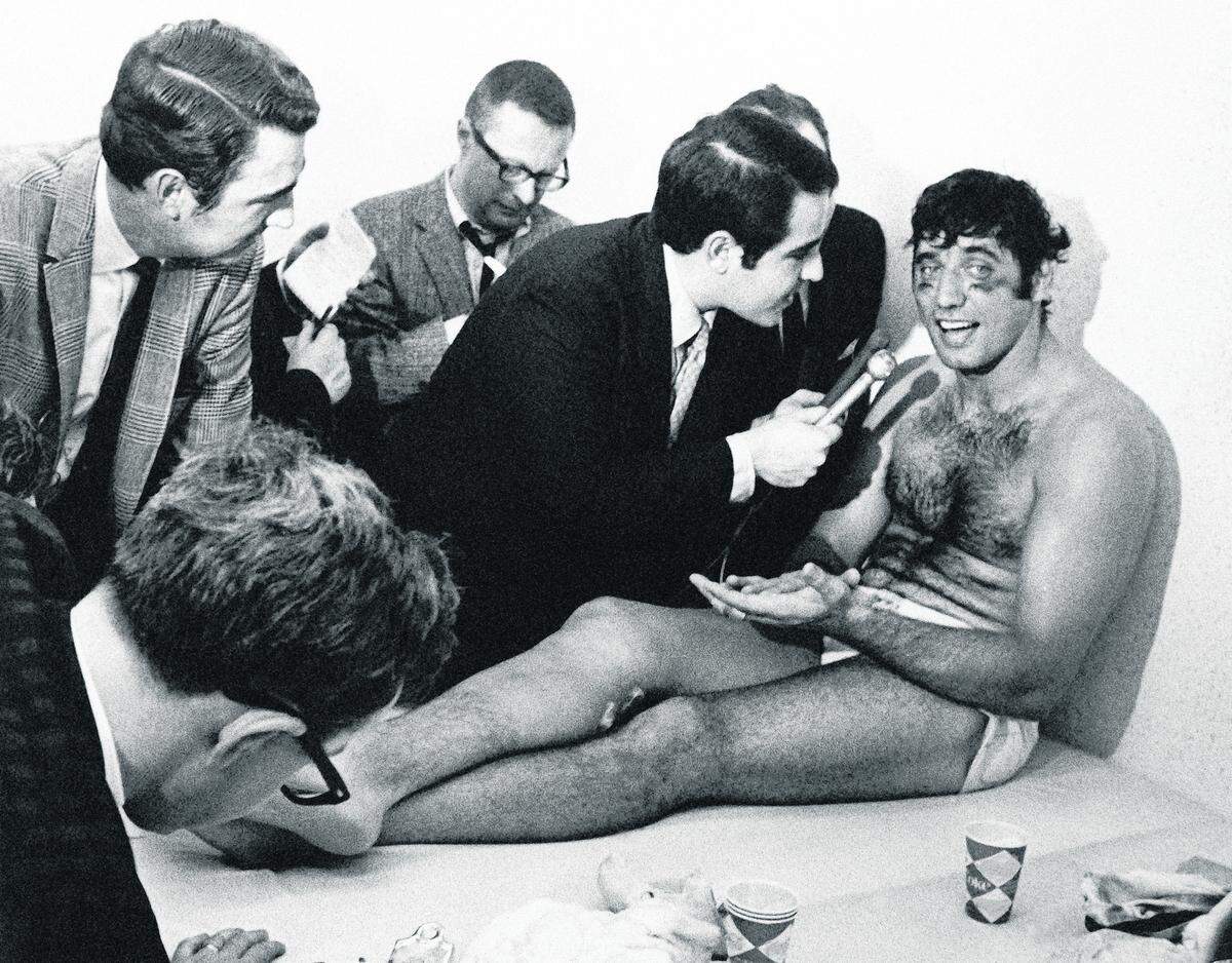 Smiling and talkative after the Super Bowl game at night New York Jets quarterback Joe Namath talks with reporters as he rests on a training table in the dressing room on Jan. 13, 1969 in Miami, Florida. Namath played most of the game completing 17 passes in 28 attempts in the 16 to 7 win over the Baltimore Colts.