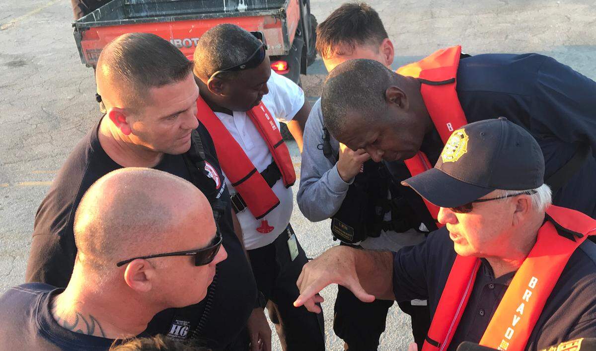 Miami-Dade Mayor Carlos Gimenez, bottom right, talks with Miami and county rescue workers on the tarmac of the Freeport airport in Grand Bahama on Friday, Sept. 6, 2019. To his right is Maurice Kemp, a deputy mayor and Miami-Dade’s acting fire chief.