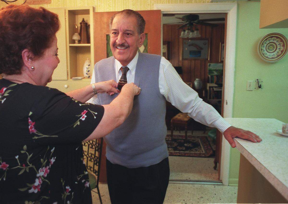 Emilio Milian gets his tie straightened by his wife, Emma Mirta Milian, in 1999 just before leaving for the radio station. Milian is the Cuban-born radio broadcaster who had his legs blown off in a car bomb in 1976.