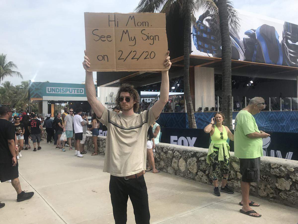 Seth Phillips, best known on Instagram as the Dude with Sign, offers a marketing tease with his protest message of South Beach’s Ocean Drive on Friday, Jan. 31, 2020. Phillips, who has 4 million followers on Instagram, gained fame by holding up ironic protest messages in New York, and he’s part of the viral marketing arena underway in the run-up to Super Bowl 54 in Miami Gardens.