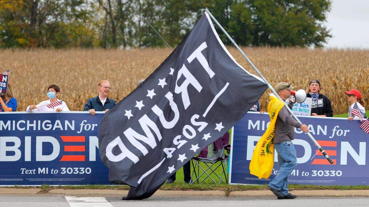 One of more than 300 Trump supporters walks past a group of Biden backers in Howell, Michigan in October 2021.