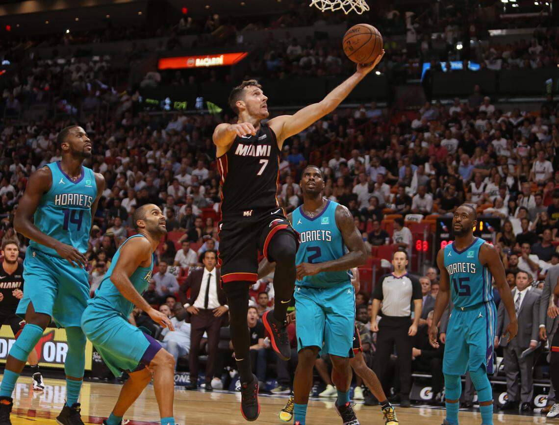 Miami Heat guard Goran Dragic goes to the basket against Charlotte Hornets forward Marvin Williams (2) Michael Kidd-Gilchrist (14) Tony Parker (9) and Kemba Walker (15) during a home game at the AmericanAirlines Arena in Miami.