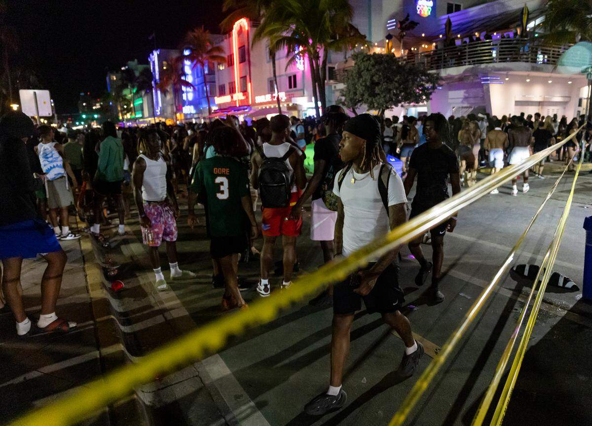 Police place caution tape to control crowds and direct traffic as people gather on Ocean Drive during spring break on Saturday, March 11, 2023, in Miami Beach, Fla.