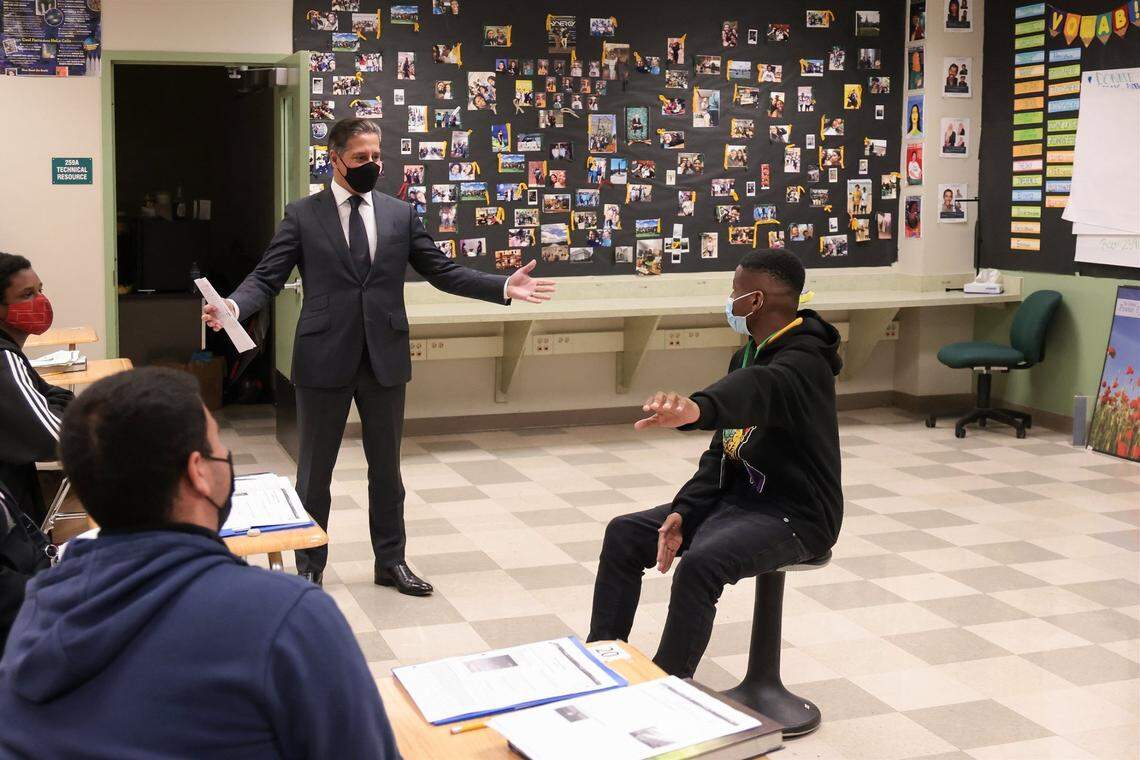 Superintendent Alberto Carvalho, center, subs-in during 9th grade environmental science class at Miami Jackson Senior High where he started his career in education, in response to teacher shortage due teachers taking sick days or high cases of COVID-19 on Tuesday, January 4, 2022 in Miami, Florida. The students Maven Cassamajor, right, and Sergio Urraca, lower left, state their cases regarding if changing the trends of global warming is possible as Carvalho listens.