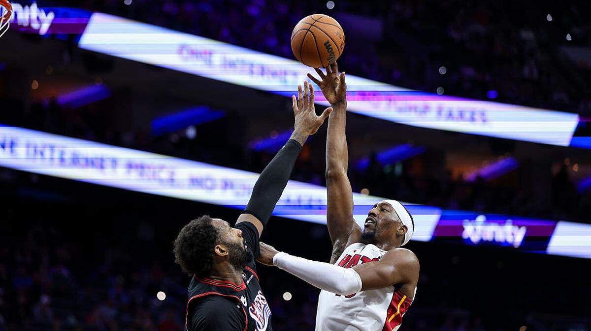 Bam Adebayo #13 of the Miami Heat shoots against Andre Drummond #1 of the Philadelphia 76ers during the third quarter at Xfinity Mobile Arena on November 23, 2025 in Philadelphia.