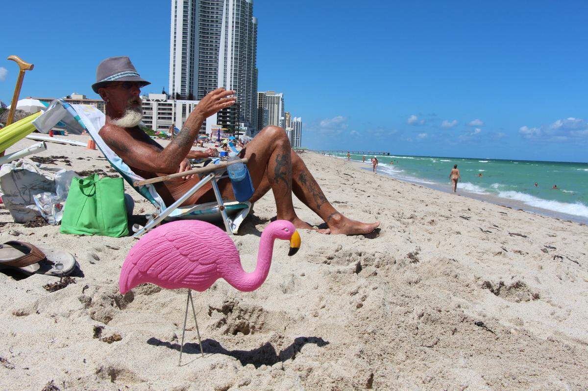At Haulover, a nude sunbather has the company of a plastic flamingo.