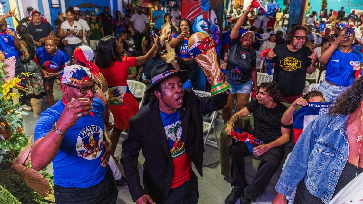 Haiti's soccer team fan Pierrot Mervilier holds a replica of FIFA World Cup trophy while celebrating during the halftime break of the Haiti vs. Scotland Fifa World Cup game, in Boston, at a game watch party at the Haitian Cultural Center in Little Haiti, on Saturday June 13, 2026.