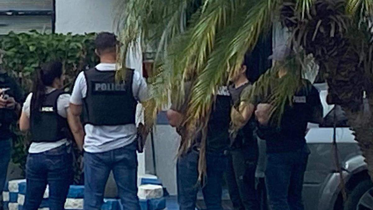 Miami-Dade police detectives stand outside a home in South Miami Heights after they served a search warrant Wednesday, Nov. 29, 2023, because they said the house is operating as an unlicensed assisted living facility.