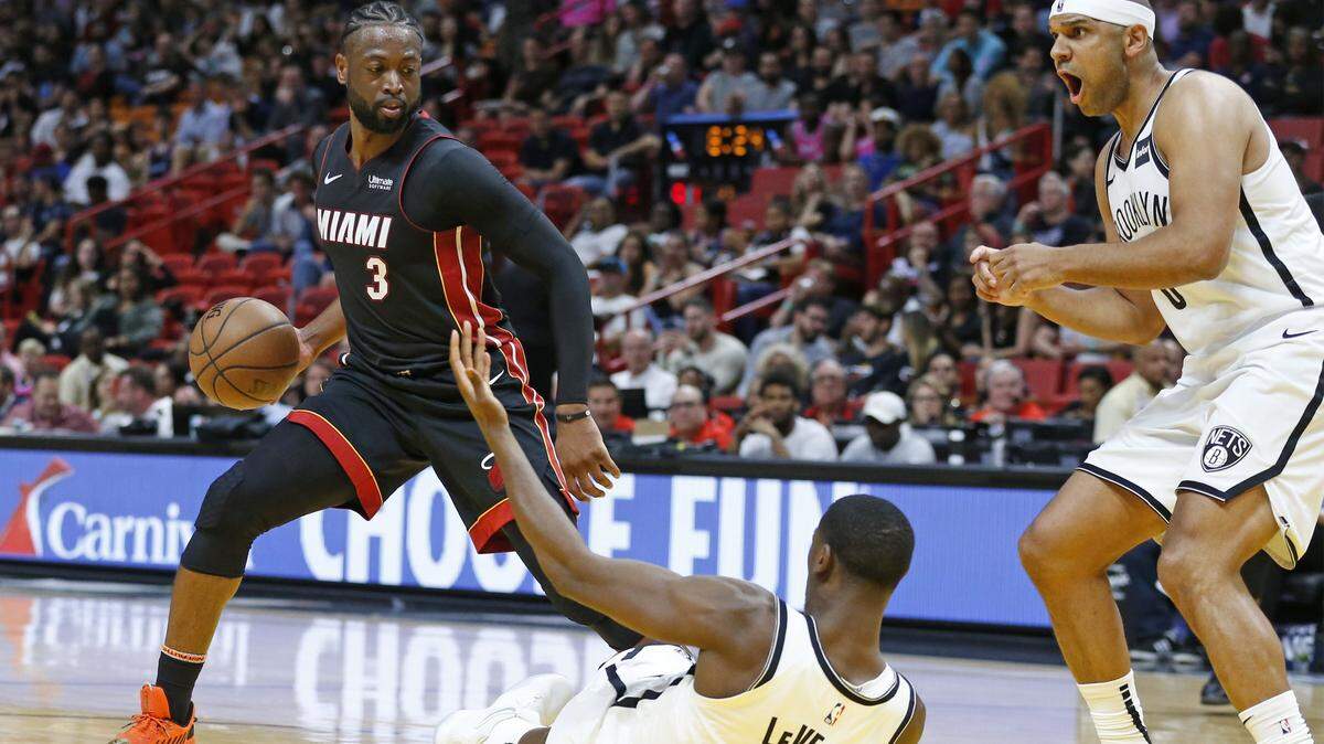 El escolta del Heat Dwyane Wade (3) escapa de la marca de los jugadores de los Nets Caris LeVert (22) y Jared Dudley (6) el sábado 2 de marzo de 2019 en el American Airlines Arena de Miami.