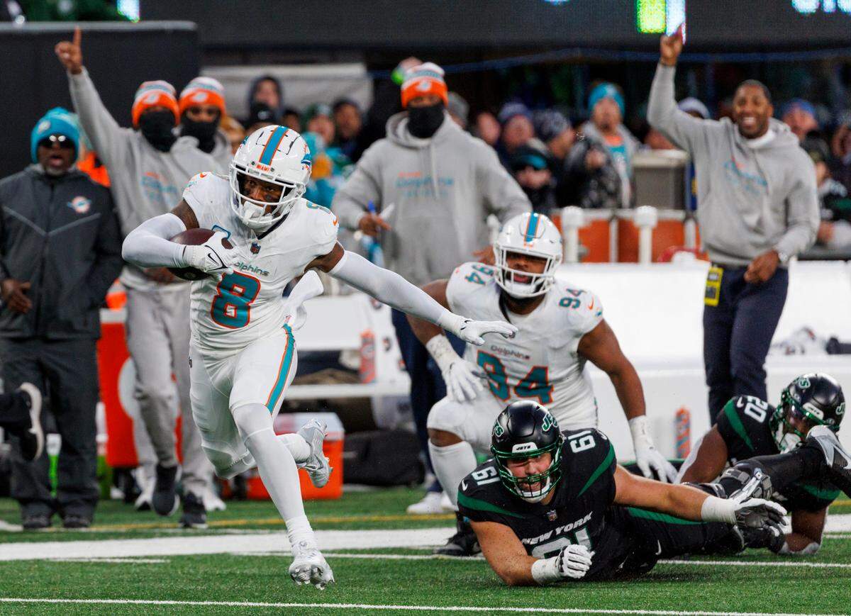 Miami Dolphins safety Jevon Holland (8) runs after intercepting a pass during second quarter of an NFL football game against the New York Jets at MetLife Stadium on Friday, Nov. 24, 2023 in East Rutherford, New Jersey.