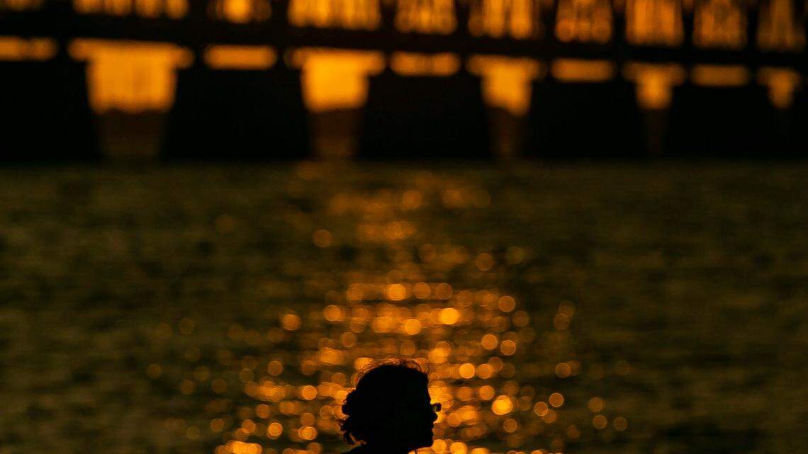 Lauren Nechamkin watches the sunset over Henry Flaglers Overseas Railroad at Bahia Honda State Park near Big Pine Key on Monday, October 11, 2021.