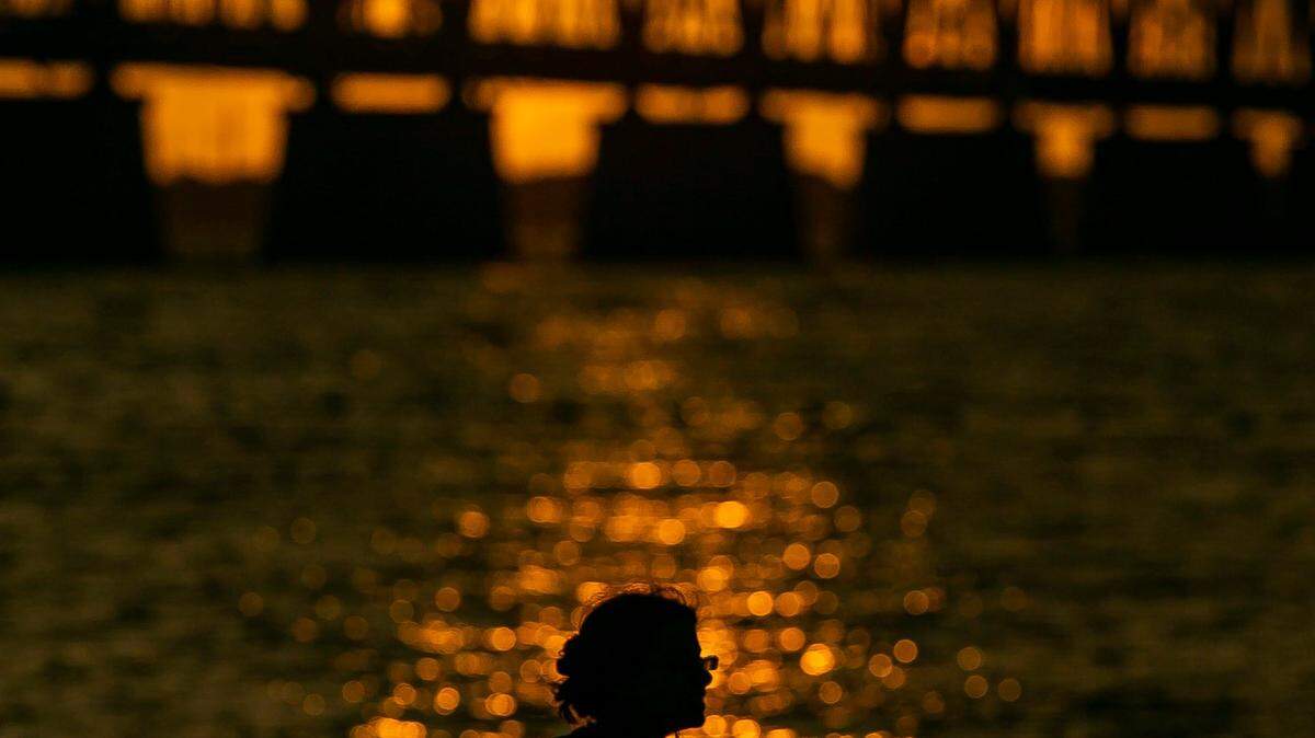Lauren Nechamkin watches the sunset over Henry Flaglers Overseas Railroad at Bahia Honda State Park near Big Pine Key on Monday, October 11, 2021.