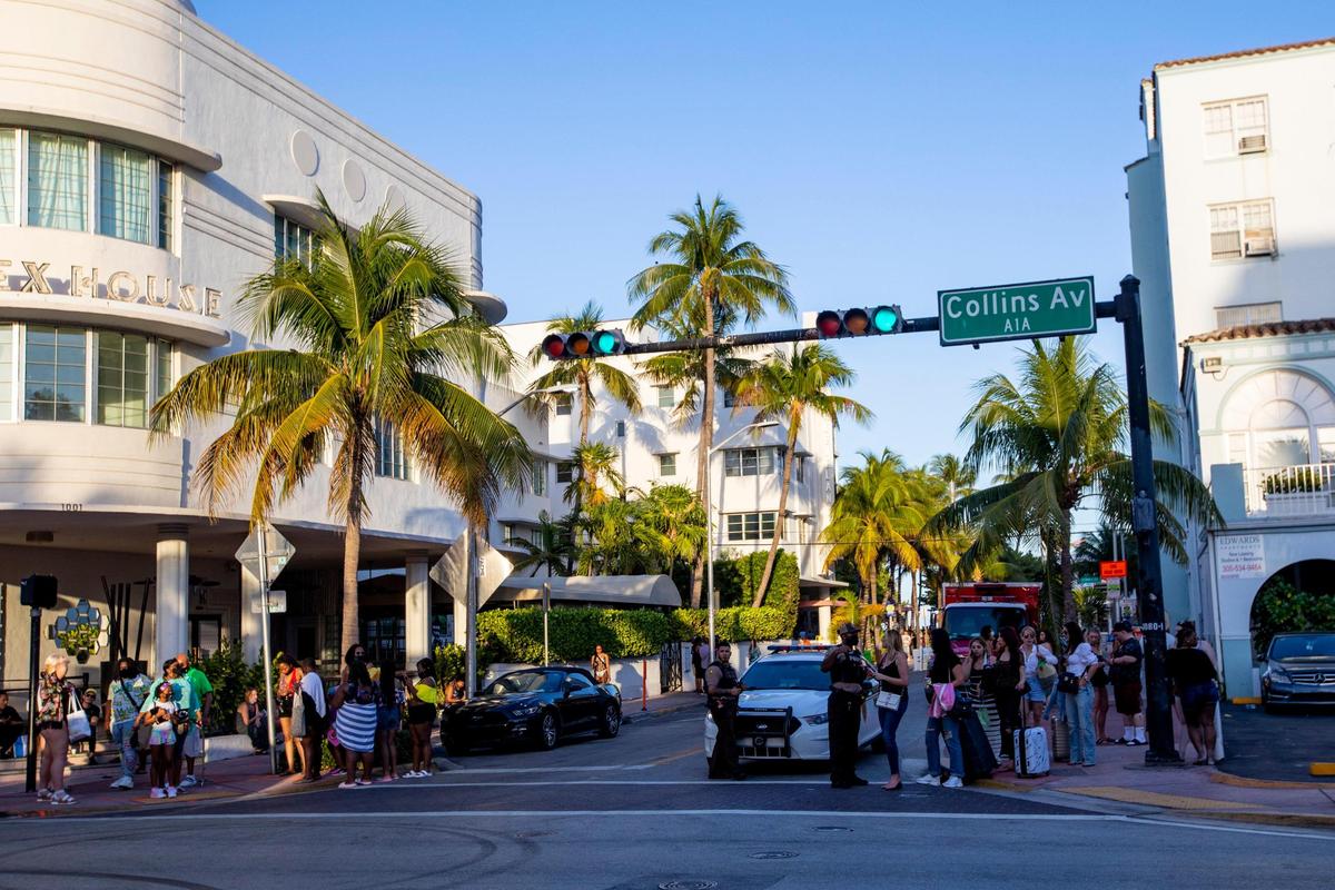 People speak with Miami Beach police officers while on Collins Avenue before curfew in Miami Beach, Florida, on Sunday, March 28, 2021.