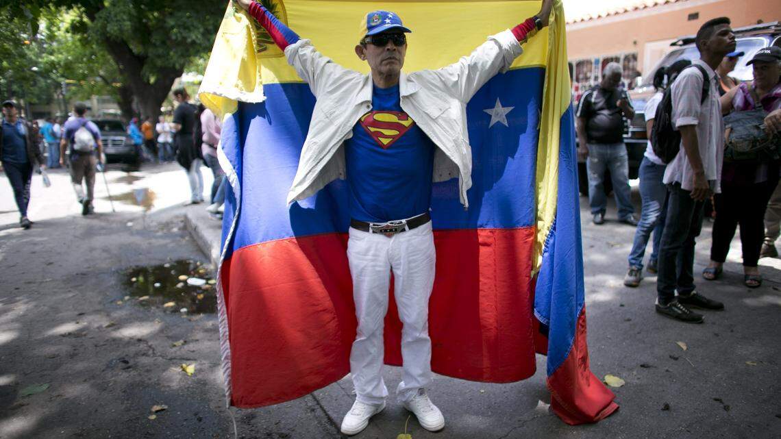 A man wearing a Superman logo shirt and holding up a Venezuelan flag protests the upcoming presidential election in Caracas, Venezuela, on Wednesday, May 16, 2018. Only a few hundred hard-liners showed up Wednesday for a march to the offices of the Organization of American States to denounce the 'fraudulent' election, a pale comparison to the masses that took to the streets a year ago attempting to force Nicolas Maduro from office during months of demonstrations that left more than 130 people dead, many at the hands of security forces.