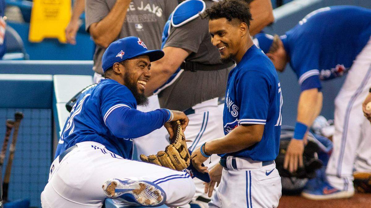 Toronto Blue Jays’ Teoscar Hernandez, left, and Santiago Espinal laugh after their intrasquad game in Toronto on Thursday, July 9, 2020.
