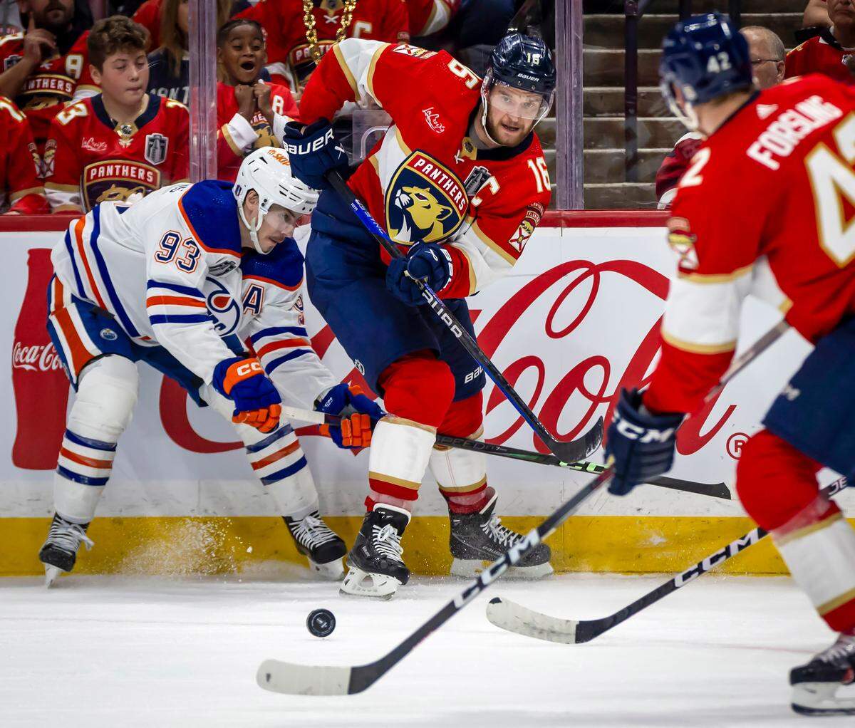 Sunrise, Florida, June 8, 2024 - Florida Panthers center Aleksander Barkov (16) passes the puck to Florida Panthers defenseman Gustav Forsling (42) as Edmonton Oilers center Ryan Nugent-Hopkins (93) defends on the play in second period action during game 1 of the Stanley Cup Final at Amerant Arena in Sunrise, Florida.