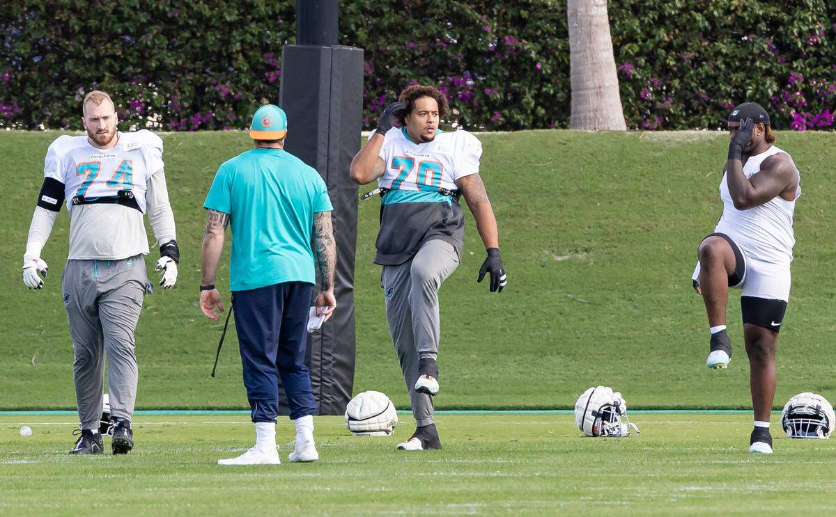 Miami Dolphins offensive tackles Liam Eichenberg (74) and Kendall Lamm (70) stretch during team practice at the Baptist Health Training Complex on Thursday, Dec. 5, 2024, in Miami Gardens, Fla.